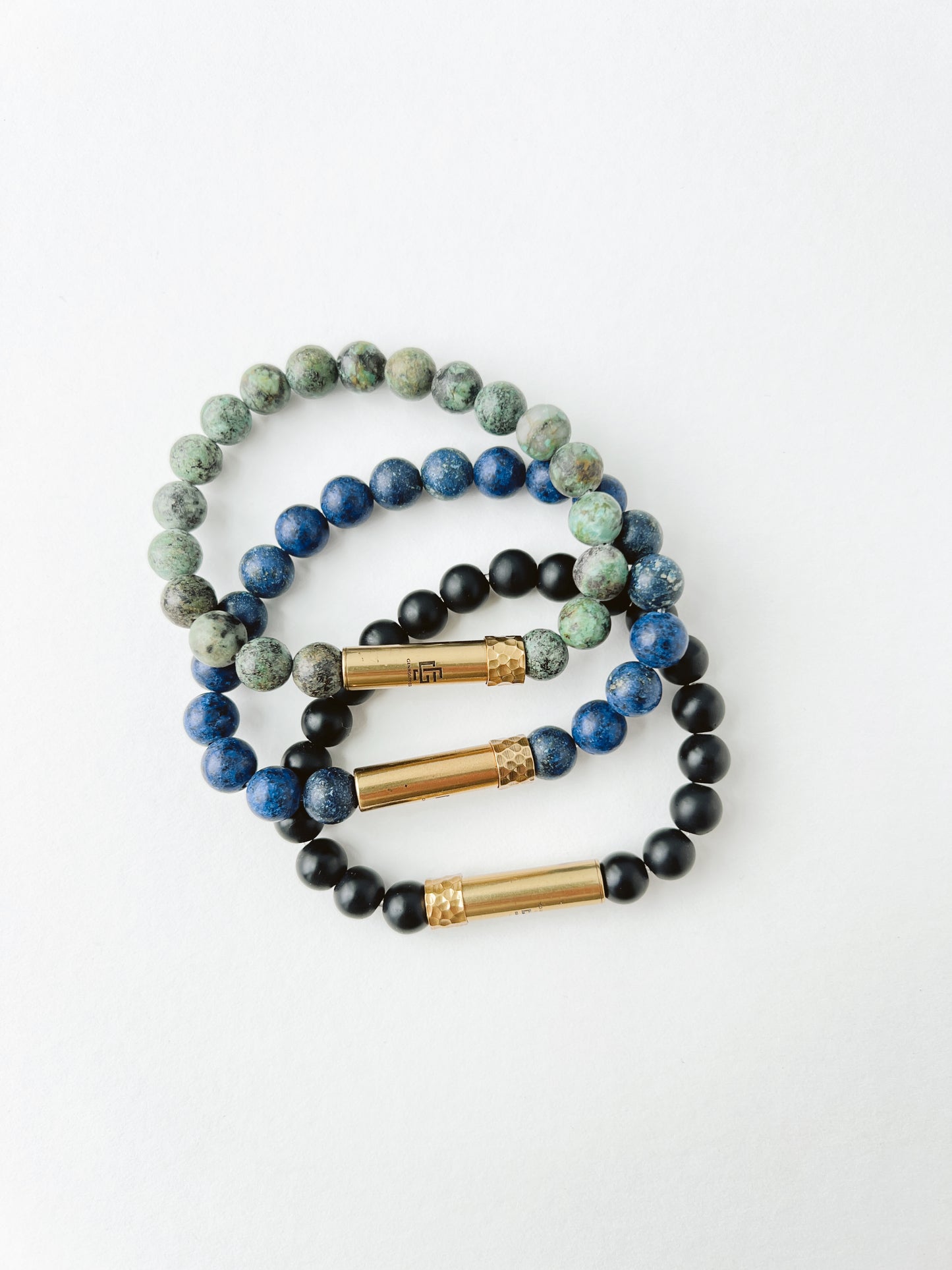 Set of beaded bracelets with gold accents on a white background