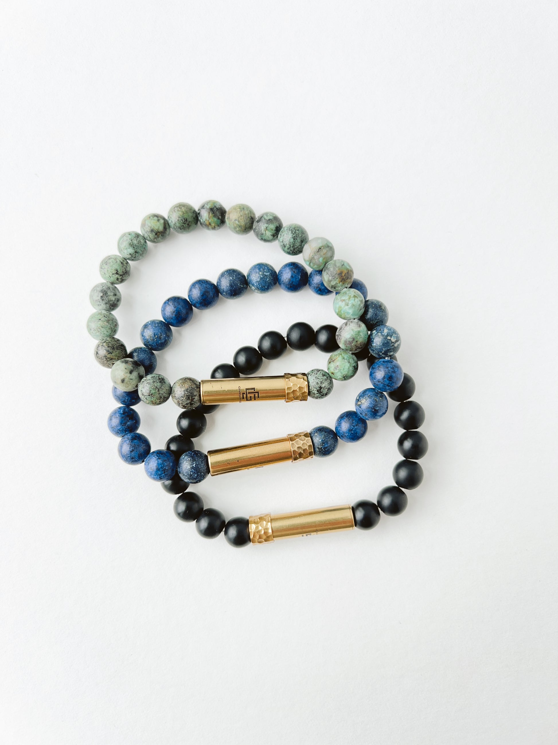 Set of beaded bracelets with gold accents on a white background