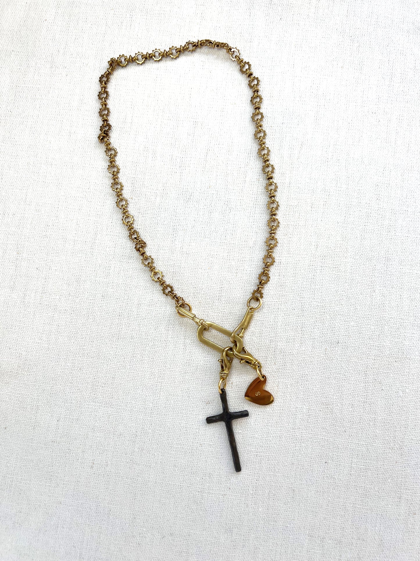Necklace with cross and heart pendant on a white background