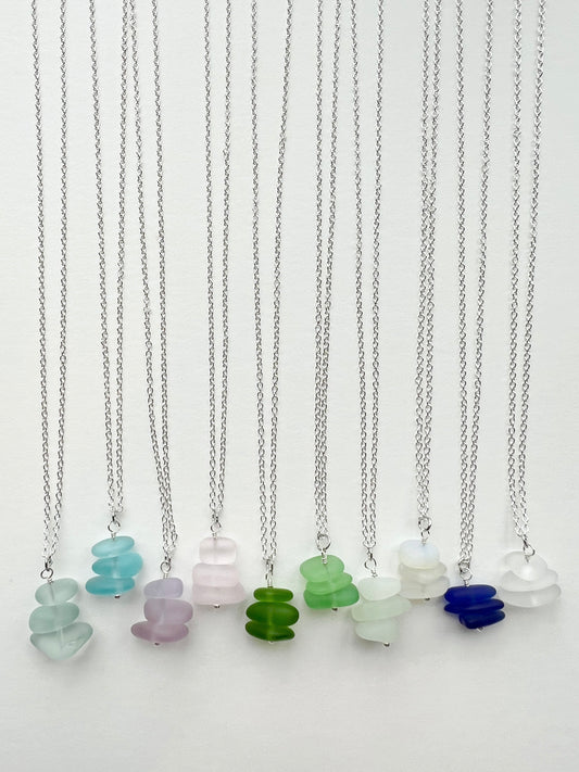 Beach glass necklaces with colorful glass pendants on a white background