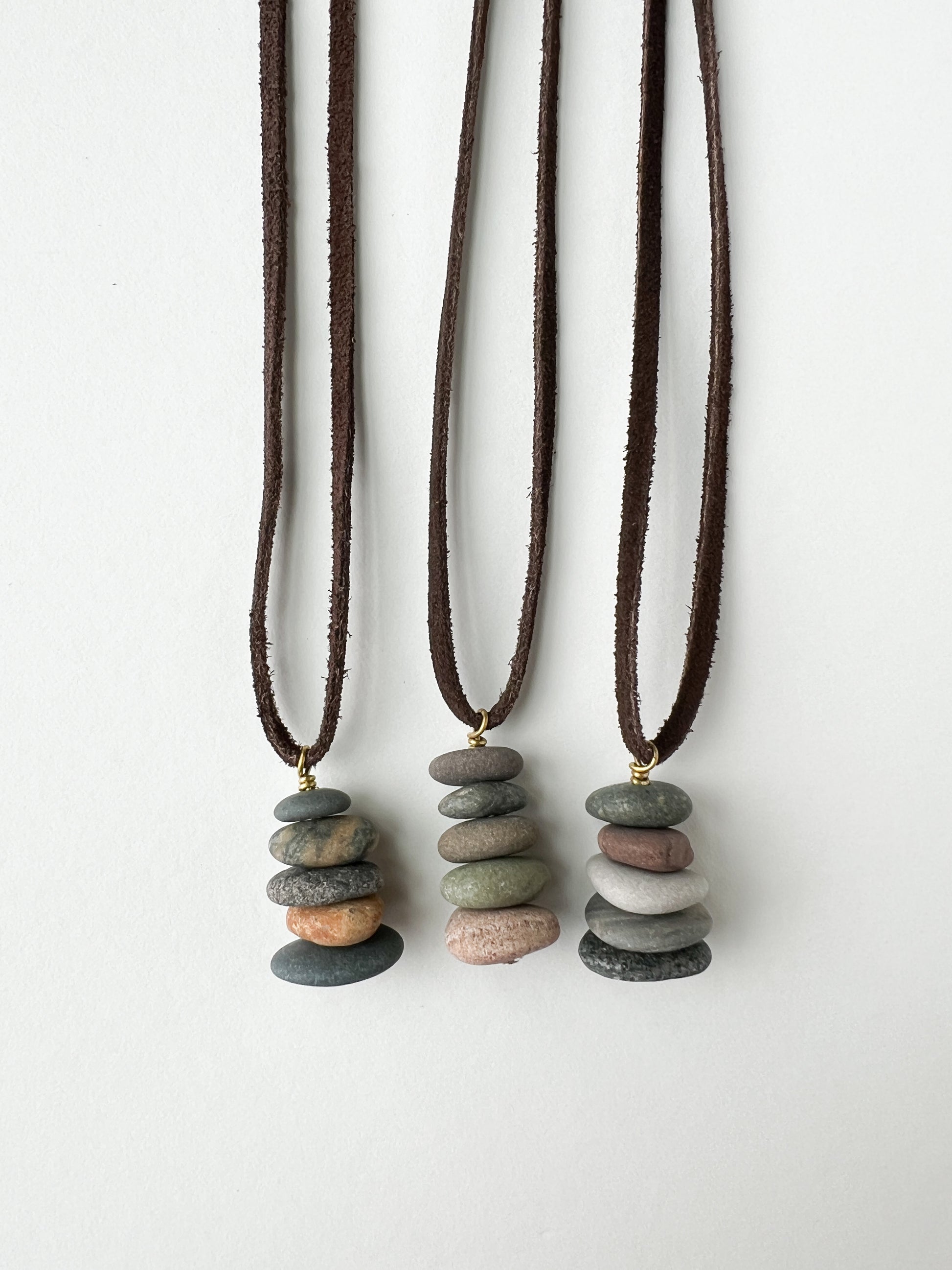 Stacked lake stones on a leather cord necklace.
