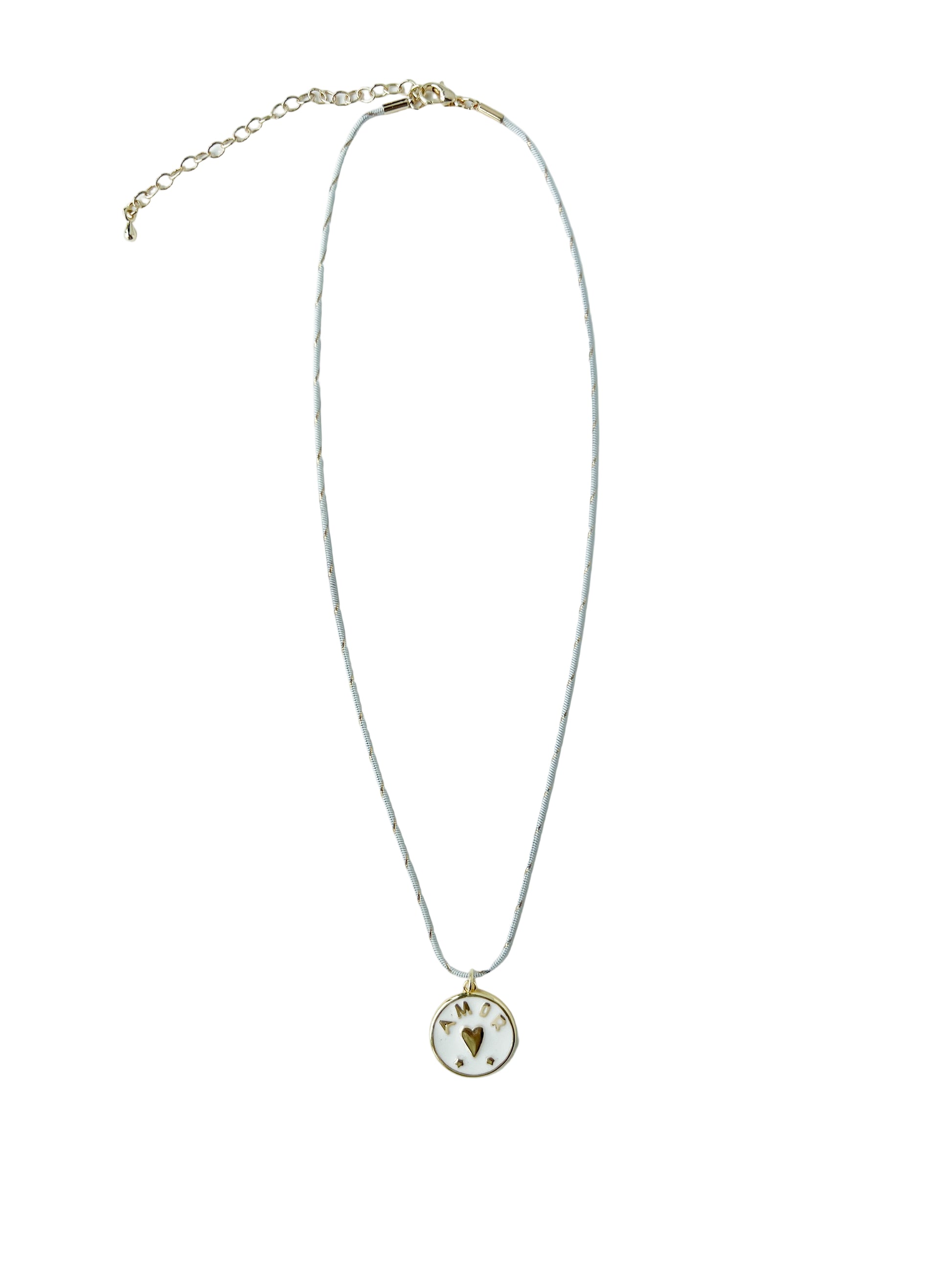 White and gold striped necklace with a circular 18k gold filled pendant featuring a heart and the word Amor on a light gray background