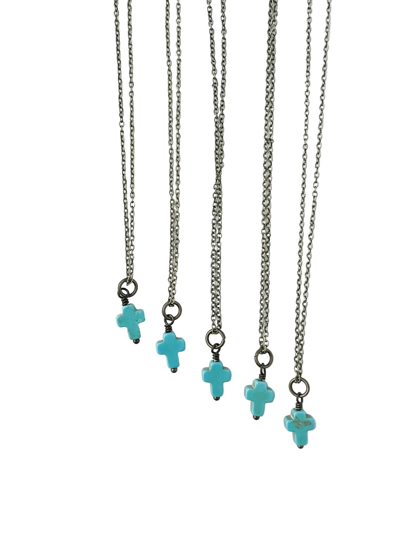 Five bronze necklaces with turquoise cross charms on a white background