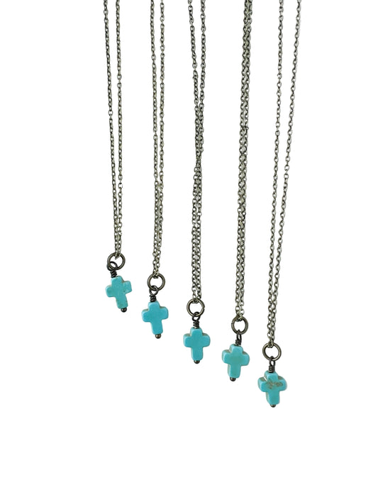 Five bronze necklaces with turquoise cross charms on a white background