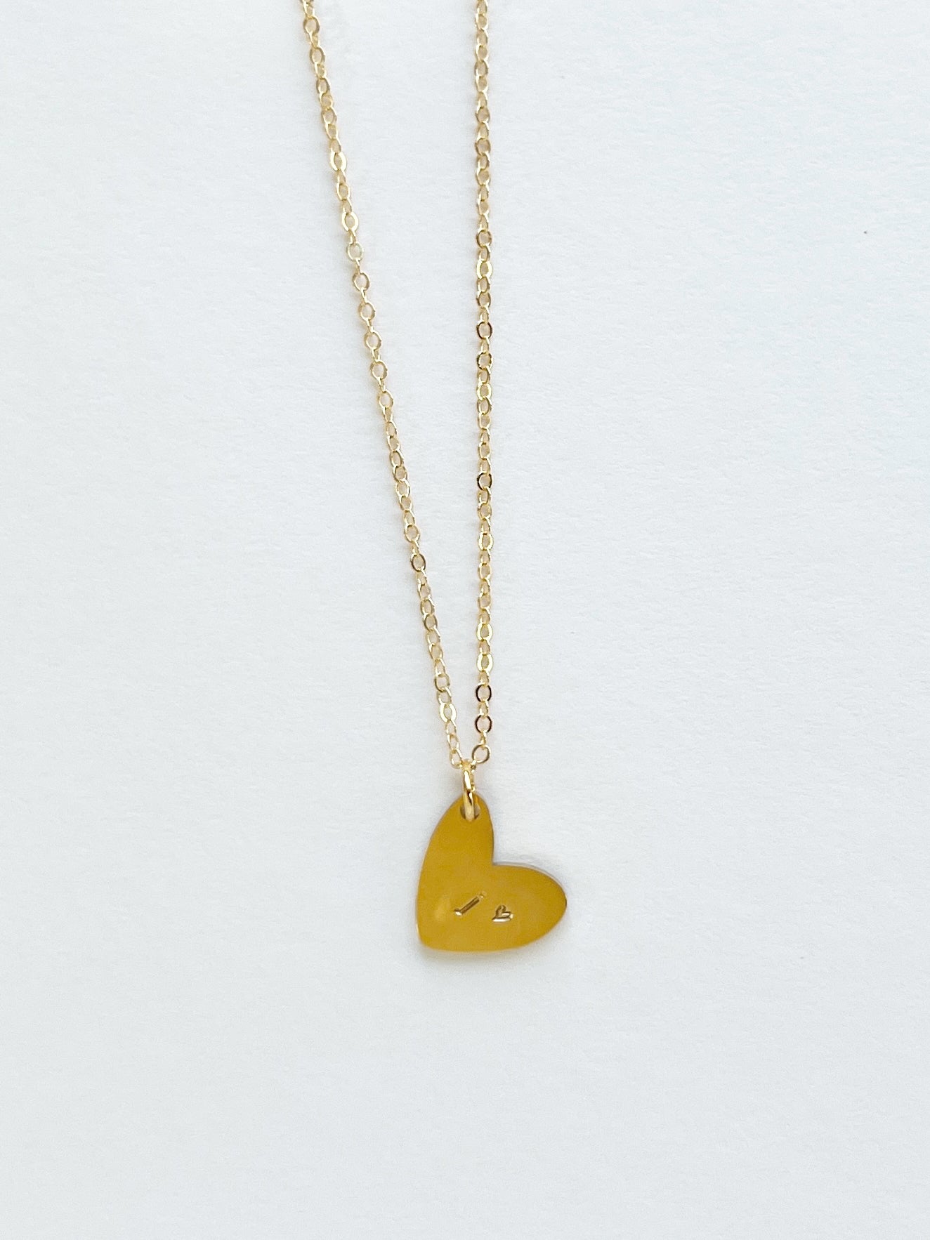 Gold heart-shaped pendant necklace on a white background
