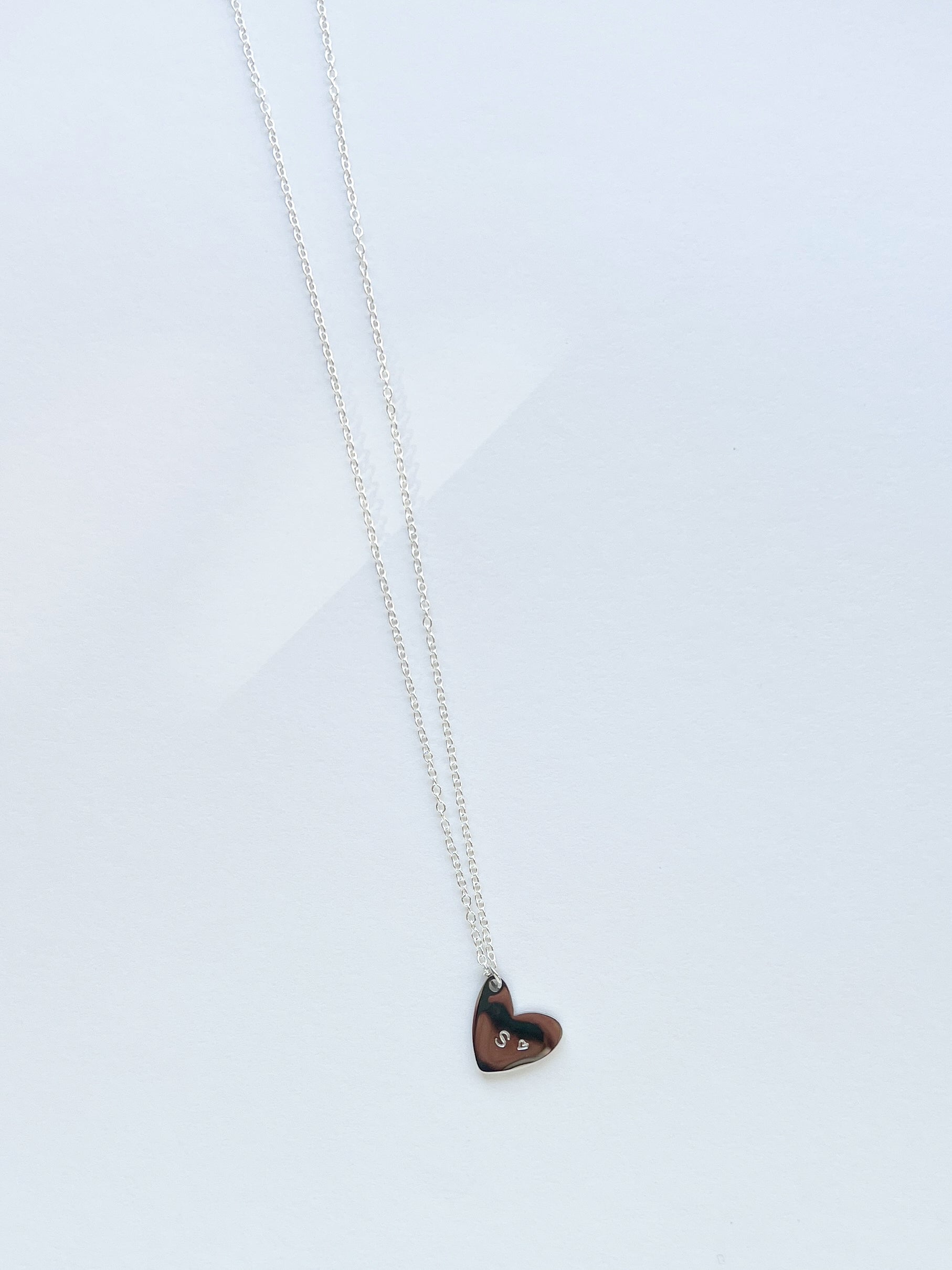 Heart-shaped pendant necklace on a light gray background