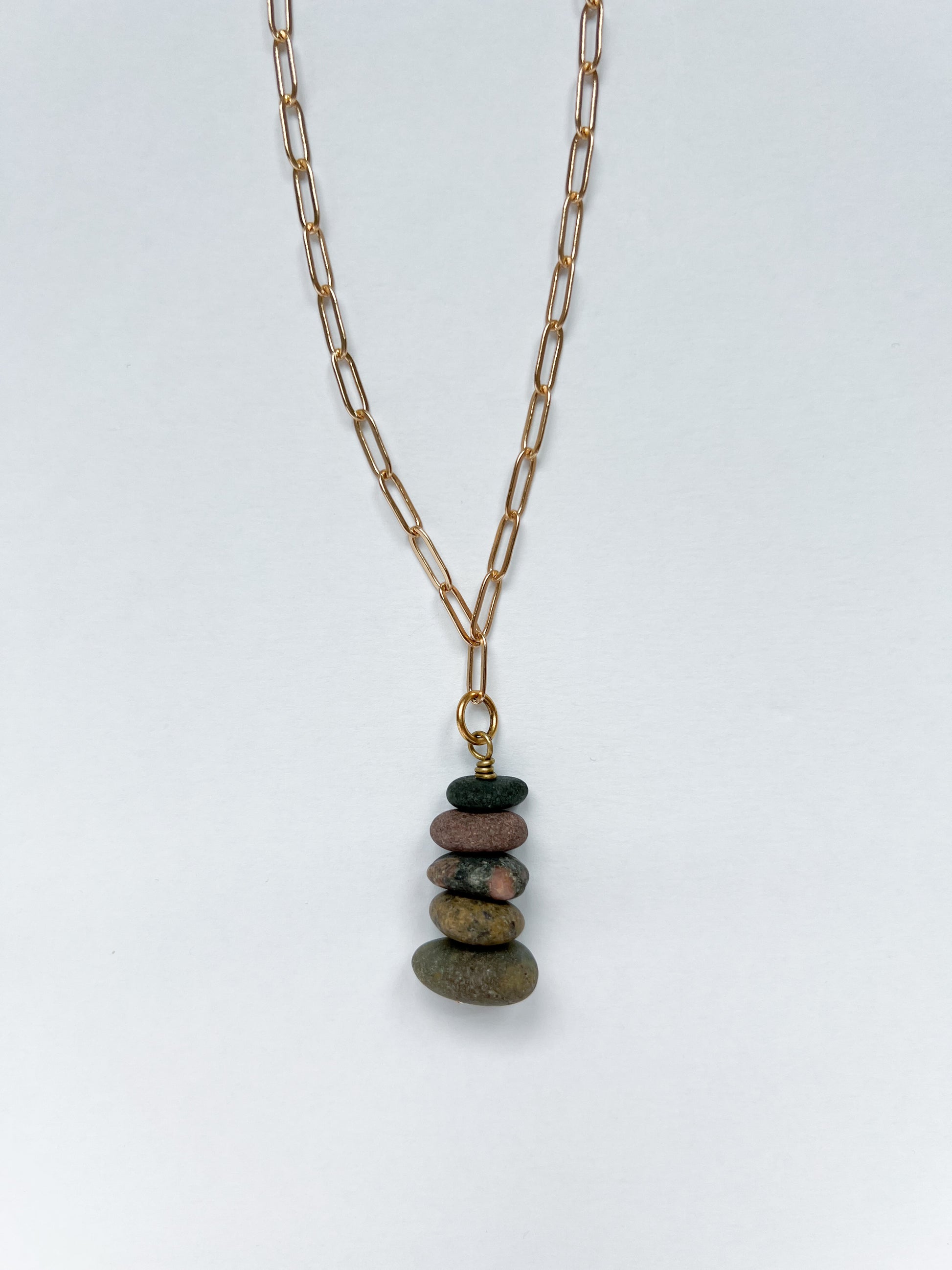 Brushed gold paperclip chain necklace with a 5 lake stones stacked in charm on a white background.