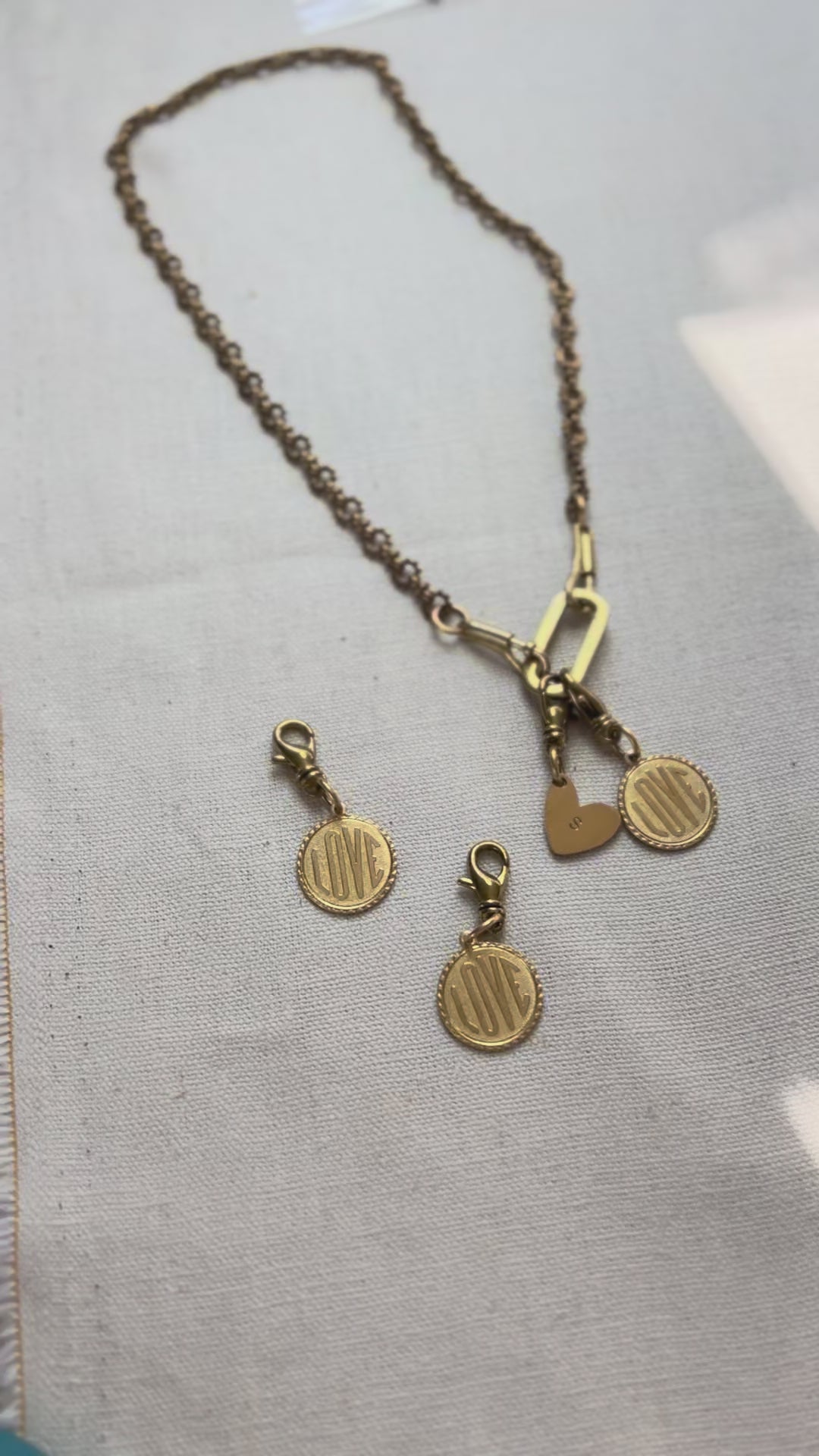 Video of a charm necklace with love token charms